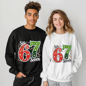 May include: Black and white sweatshirts with a festive design. The design features the numbers "67" in red and green, surrounded by string lights and the word "Six" and "Seven". The sweatshirts are worn by two people.
