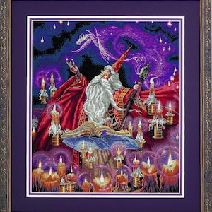 May include: Framed cross-stitch art depicting a wizard with a long white beard, red robes, and a tall hat. The wizard is surrounded by candles and a dragon in a starry night sky. The artwork is framed in a dark, ornate frame.