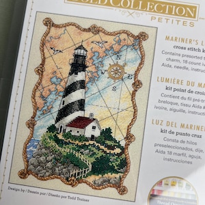以下が含まれることがあります： Dimensions Gold Collection Petitesのクロスステッチキット「Mariner's Lighthouse」。黒と白の縞模様の灯台、岩場の崖、コンパスローズ、カモメが描かれています。完成サイズは12.7cm x 17.7cmです。