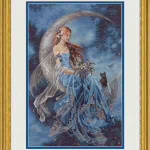 Könnte beinhalten: Ein gerahmtes Kreuzstichbild, das eine Figur mit langem rotem Haar und durchscheinenden Flügeln auf einer Mondsichel sitzend zeigt. Die Figur trägt ein fließendes blaues Kleid mit Spitzendetails, hält einen Blumenstrauß und wird von einer kleinen schwarzen Katze begleitet.