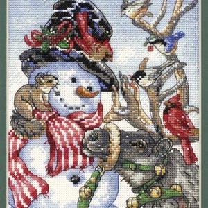 May include: A cross-stitch embroidery featuring a snowman wearing a black top hat with holly, a red and white striped scarf, and an orange carrot nose. A small brown animal sits on the snowman's shoulder, while a reindeer with a green bell collar and several birds on branches are positioned to the right.