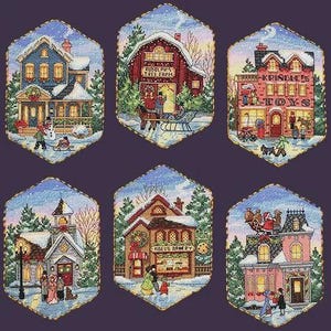 Op de afbeelding: Zes zeshoekige kruissteekpatronen met winterse dorpsgezichten. De gebouwen omvatten een huis, Rudolph's Tree Farm, Krindle's Toys, een kerk, Noel's Bakery en een huis met een slee op het dak, elk met sneeuw, bomen en figuren in de scènes.