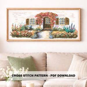 May include: A framed cross-stitch pattern depicting a cottage with a door and windows, surrounded by flowers and greenery. The artwork is in a wooden frame. Text at the bottom reads "CROSS STITCH PATTERN - PDF DOWNLOAD".