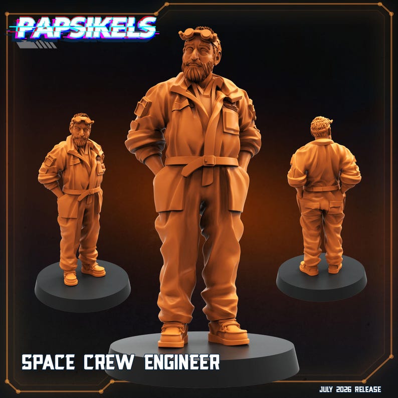 May include: An orange miniature figurine of a space crew engineer with a beard, wearing a jumpsuit with pockets, a belt, and goggles on the forehead. The figure stands on a circular black base. Text reads PAPSIKELS, SPACE CREW ENGINEER, JULY 2026 RELEASE.
