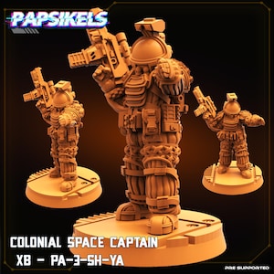 Può includere: Tre figurine arancioni di Colonial Space Captain. La figura centrale è la più grande, affiancata da due versioni più piccole. Ogni figurina è dotata di elmetto, armatura e arma. Il testo "PAPSIKELS" e "COLONIAL SPACE CAPTAIN" sono visibili.