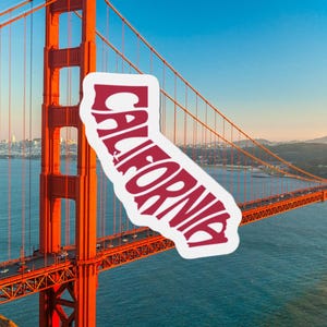 May include: A sticker in the shape of California with the word "CALIFORNIA" in red, overlaid on a photo of the Golden Gate Bridge. The bridge is a vibrant orange, spanning across blue water under a clear sky.