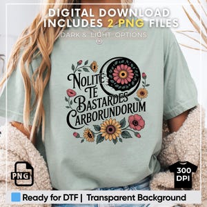 May include: A light blue t-shirt with a floral design and the text "Nolite Te Bastardes Carborundorum".