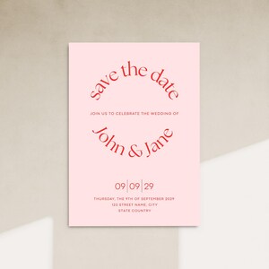 Puede incluir: Tarjeta de guardar la fecha rosa con texto rojo. El texto dice "Save the date" en un c&iacute;rculo, seguido de "Join us to celebrate the wedding of John & Jane". La fecha se indica como "09/09/29" y la fecha completa es "Thursday, the 9th of September 2029". La direcci&oacute;n se indica como "123 Street Name, City, State Country".