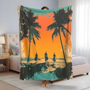 May include: A beach-themed blanket featuring a vibrant sunset scene with palm trees and silhouettes of surfers. The blanket has a distressed, vintage look with orange, teal, and black colors. The design evokes a tropical, coastal vibe.