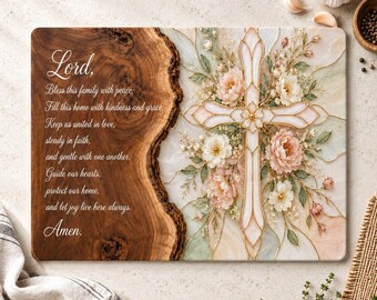 May include: A rectangular cutting board featuring a natural wood grain edge on the left and a floral cross design on the right. The text reads: Lord, Bless this family with peace. Fill this home with kindness and grace. Keep us united in love, steady in faith, and gentle with one another. Guide our hearts, protect our home, and let joy live here always. Amen.