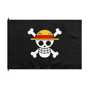 May include: Black flag featuring a white skull and crossbones design with a yellow straw hat and red band. The skull has two black eyes and a smiling mouth. The flag is rectangular and has two white clips at the top.