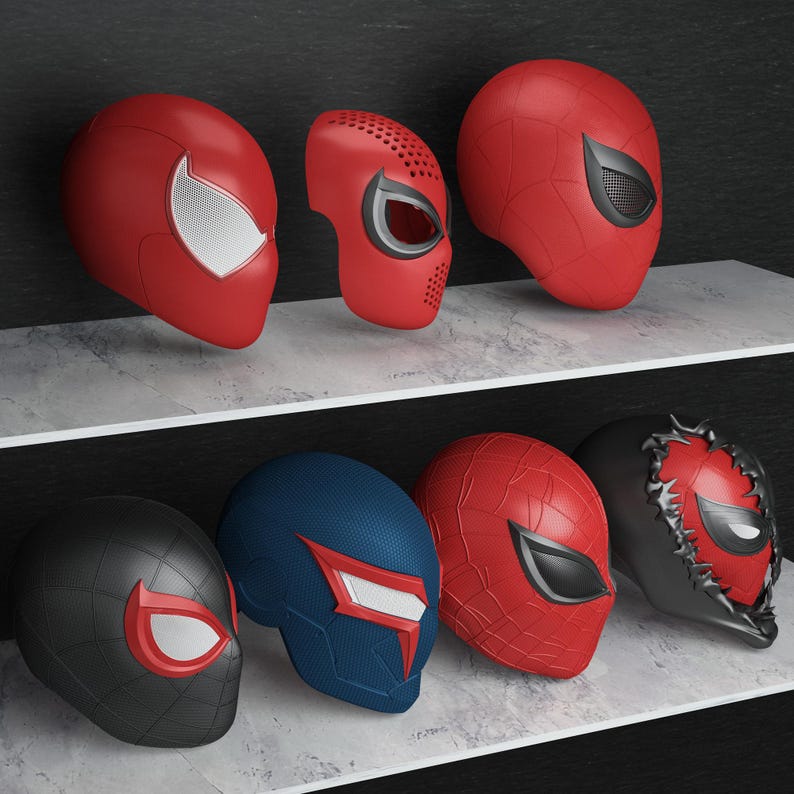 May include: A collection of Spider-Man themed masks in various designs and colors. The masks are primarily red, black, and blue, with white and black eye details. The masks are displayed on shelves, showcasing the different styles.