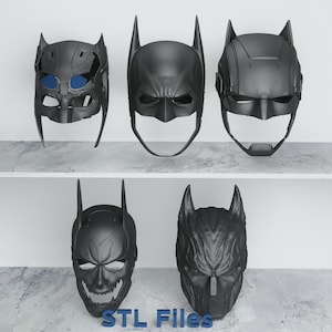 Op de afbeelding: Vijf zwarte Batman-maskers met verschillende ontwerpen worden op twee planken getoond. De maskers hebben verschillende oorstijlen, gezichtskenmerken en texturen. De tekst "STL Files" is onderaan zichtbaar.