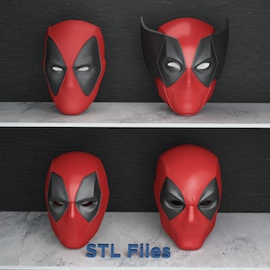 May include: Four red and black Deadpool masks are displayed on a shelf. The masks have a textured surface and feature black eye shapes and a red face. One mask has black ear-like extensions. The text "STL Files" is at the bottom.