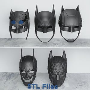 May include: Five black Batman-style masks are displayed on shelves. The masks vary in design, with features like pointed ears and different facial expressions. The text "STL Files" is visible at the bottom.