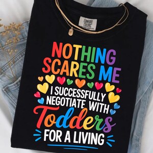 a black t-shirt with a colorful graphic design and text printed on it.