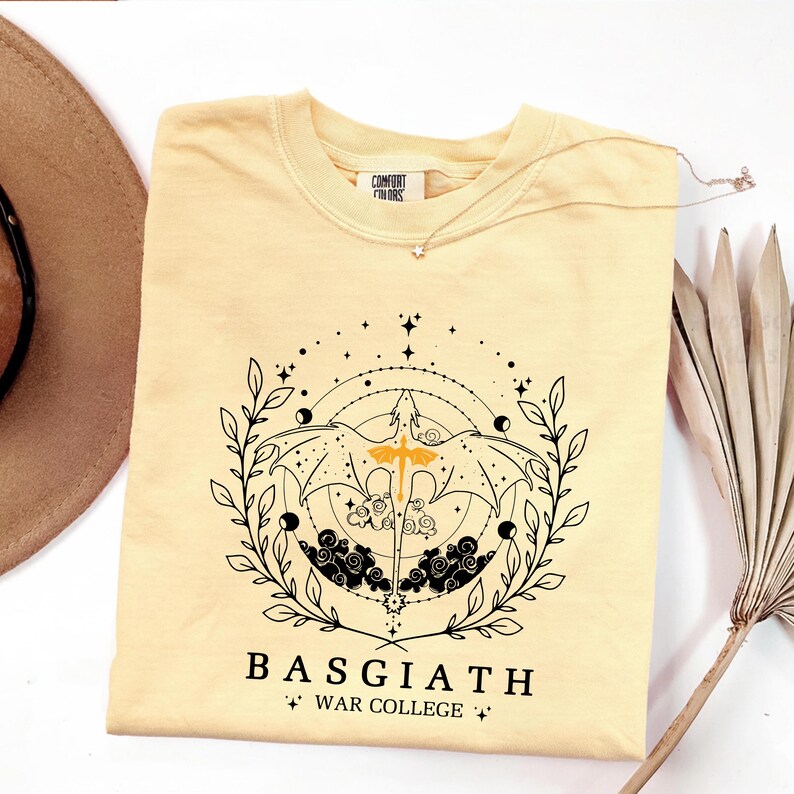 a yellow t-shirt with a graphic design, a necklace, a hat, and a plant.