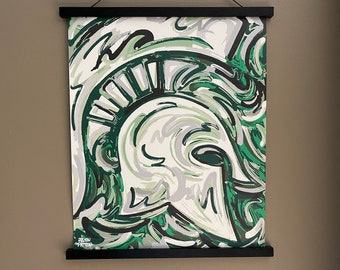 Lámina enrollada de 16" x 20" con diseño de casco espartano de la Universidad Estatal de Michigan, obra de Justin Patten (Storm Striker Art, exalumno de la Universidad Estatal de Michigan, donación de la MSU).