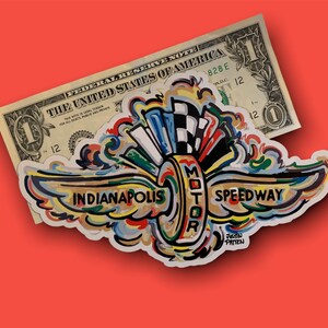 May include: A colorful sticker with a stylized depiction of a race car wheel with wings. The text "Indianapolis Motor Speedway" is written in black letters on the sticker. The artist's name, "Justin Patten", is written in smaller letters below the Speedway text.