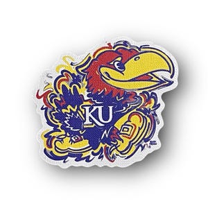 May include: A colorful, distressed-style sticker featuring the University of Kansas mascot, a blue and yellow bird with a red head, holding a basketball. The mascot is surrounded by a blue and yellow design and the letters "KU" are visible in the center.