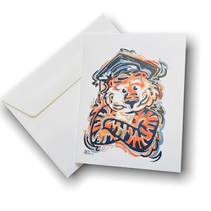 May include: A colorful illustration of a tiger wearing a graduation cap. The tiger is orange and black with blue and white accents. The tiger is smiling and has its arms crossed.