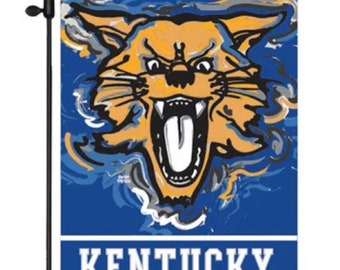 May include: A blue garden flag with a stylized illustration of a wildcat with a yellow and orange face and black markings. The text "KENTUCKY" is printed in white at the bottom of the flag.