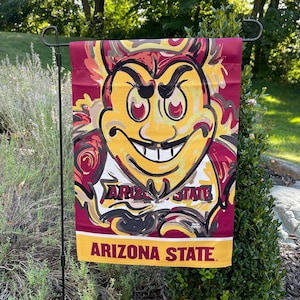 May include: A red, yellow, and black garden flag with a cartoon mascot of a devil with the text "Arizona State" on the bottom.