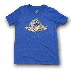 Puede incluir: Una camiseta azul real con un gr&aacute;fico colorido del logotipo del Indianapolis Motor Speedway. El logotipo presenta una rueda alada estilizada con las palabras "Indianapolis Motor Speedway" alrededor.