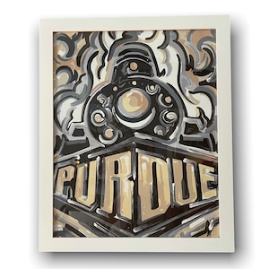 May include: A framed art print featuring a stylized train design in shades of black, gray, and beige. The word "PURDUE" is prominently displayed in bold letters across the bottom of the image. The artwork is encased in a white frame.