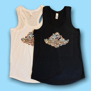 May include: Two racerback tank tops with a colorful graphic of the Indianapolis Motor Speedway logo. The tank top on the left is white and the tank top on the right is black.