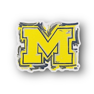 May include: A yellow letter M with a black outline and gray brushstrokes around the edges. The letter is on a white background.