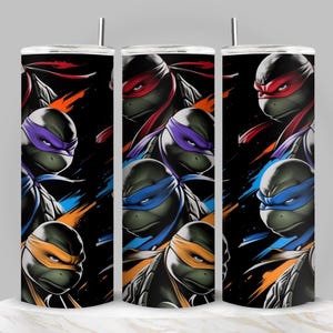 Può includere: Tre bicchieri in acciaio inossidabile con una grafica colorata dei Teenage Mutant Ninja Turtles. Ogni bicchiere presenta una tartaruga diversa con una maschera colorata: rossa, viola, blu e arancione. Lo sfondo è nero con pennellate colorate.