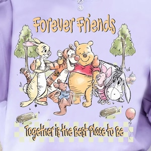 May include: A light purple sweatshirt featuring a graphic of Winnie the Pooh and friends. The phrase "Forever Friends" is above the characters, and "Together is the best place to be" is below. The design includes trees, logs, and a balloon.