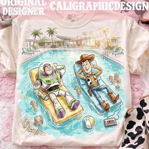 May include: Cream-colored t-shirt featuring a cartoon illustration of Buzz Lightyear and Woody relaxing by a pool. The image includes a pool, palm trees, and the text "ORIGINAL DESIGNER CALIGRAPHICDESIGN".