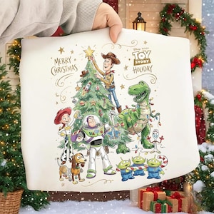 May include: A white pillowcase featuring a festive "Toy Story" holiday scene. Woody, Buzz Lightyear, and other characters decorate a Christmas tree. The words "Merry Christmas" and "Toy Story Holiday" are printed on the pillowcase.