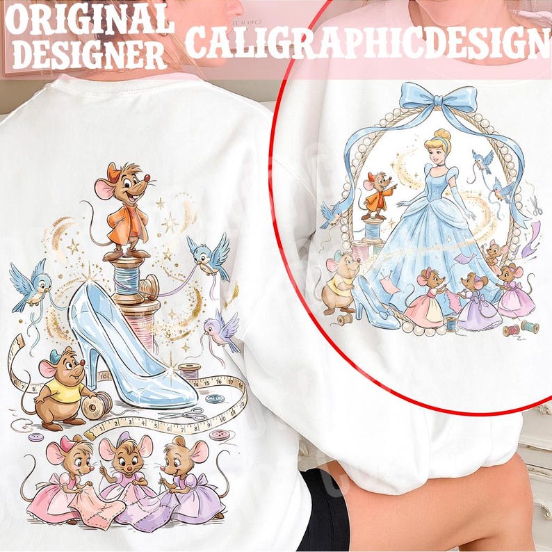 May include: White sweatshirt featuring a Cinderella-themed design. The design includes Cinderella in a blue gown, mice, birds, a glass slipper, and the text "ORIGINAL DESIGNER CALIGRAPHICDESIGN". The artwork is detailed with soft colors and whimsical elements.