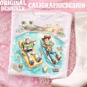 May include: White t-shirt featuring a colorful illustration of Buzz Lightyear and Woody relaxing in a pool. The image includes a pool, palm trees, and the text "ORIGINAL CALIGRAPHICDESIGNER".