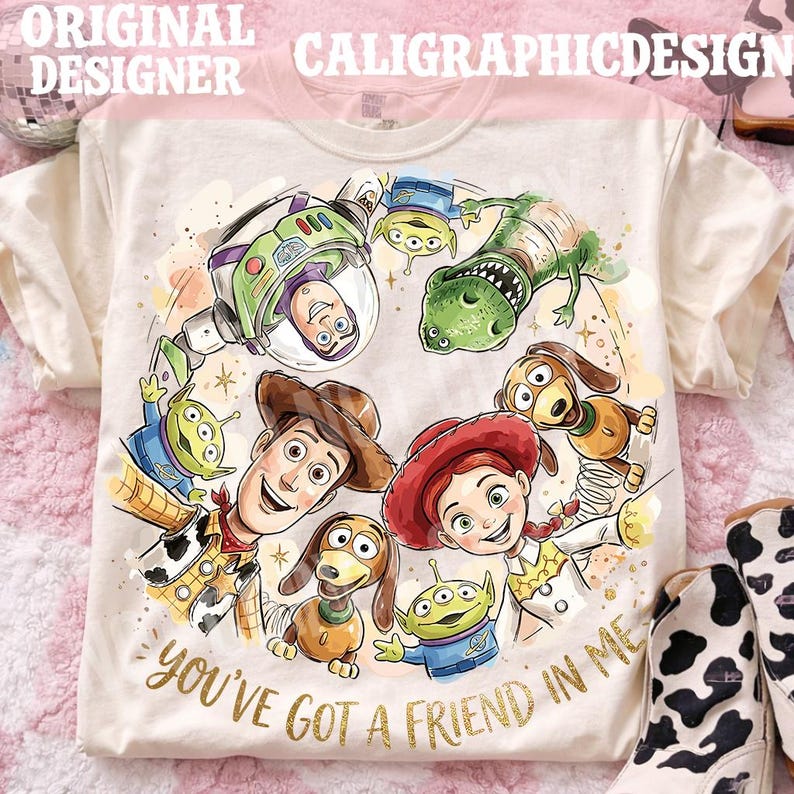 以下が含まれることがあります： クリーム色のTシャツ。アニメ映画「トイ・ストーリー」のキャラクター、ウッディ、バズ・ライトイヤー、レックスなどのカラフルなイラストが描かれています。「You've Got a Friend in Me」の文字が金色でプリントされています。半袖のシャツです。