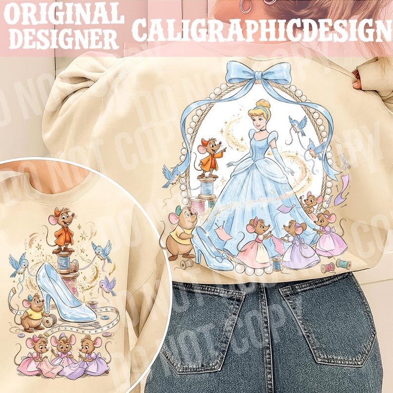 May include: Beige sweatshirt featuring a Cinderella-themed design. The graphic includes Cinderella in a blue gown, mice, birds, and a glass slipper. The text "ORIGINAL DESIGNER CALIGRAPHICDESIGN" is at the top.