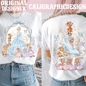 May include: White t-shirt featuring a Cinderella-themed design. The front shows Cinderella in a blue gown, surrounded by mice and a decorative frame. The back displays a glass slipper, mice, and sewing elements. Text at the top reads "ORIGINAL DESIGNER CALIGRAPHICDESIGN".