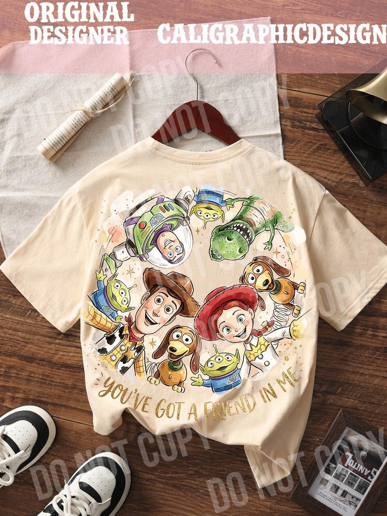以下が含まれることがあります： アニメ映画「トイ・ストーリー」のキャラクターが描かれた、ベージュ色のTシャツ。ウッディ、バズ・ライトイヤー、ジェシーなどのキャラクターと「You've Got a Friend in Me」の文字がデザインされています。