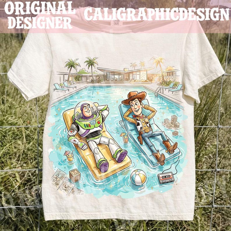 May include: Off-white t-shirt featuring a colorful illustration of Buzz Lightyear and Woody relaxing by a pool. The image includes a pool, palm trees, and the text "ORIGINAL CALIGRAPHICDESIGN DESIGNER" across the top.