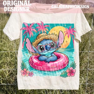 Op de afbeelding: Crèmekleurig T-shirt met een stripfiguur met een strohoed en roze zonnebril, drijvend in een roze opblaasbare ring. Het ontwerp toont een strandscène met palmbomen, een gele zon en de tekst "ORIGINAL DESIGNER" en "CALIGRAPHICDESIGN".