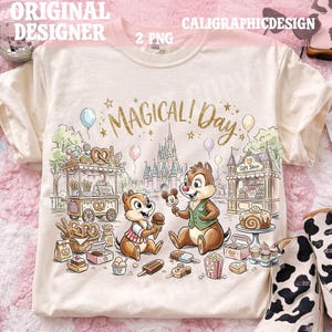 Può includere: T-shirt color crema con una grafica colorata con Cip e Ciop, carretti di cibo, un castello e la scritta "MAGICAL! Day." Il design include gelato, popcorn e altre prelibatezze. La maglietta ha maniche corte.