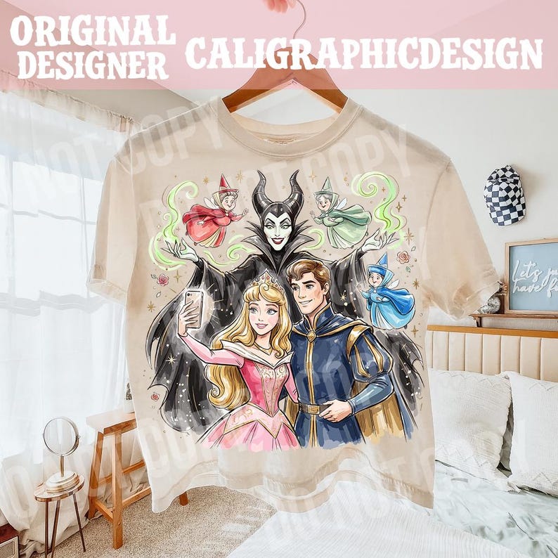 May include: A beige t-shirt with a vibrant illustration of fairy tale characters. The design includes a princess, a prince, a villain, and fairies. The text "ORIGINAL DESIGNER CALIGRAPHICDESIGN" is printed at the top of the t-shirt.