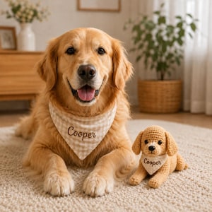May include: A golden retriever dog wearing a beige and white gingham bandana with the name Cooper embroidered in brown thread, positioned next to a small crocheted stuffed dog toy wearing a matching bandana with the name Cooper embroidered.
