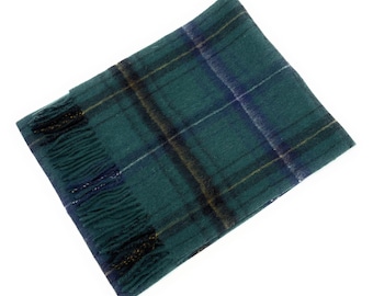 May include: A green and blue plaid scarf with fringe. The scarf features a classic tartan pattern with lines of yellow and white. The fringe is a darker shade of green and black. The scarf is made of a soft material.