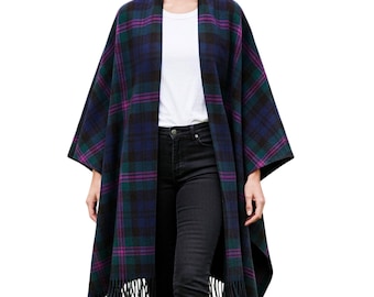 May include: A plaid cape in shades of navy, green, and purple with a fringed hem. The cape is worn over a white top and black jeans. The plaid pattern is a classic design, suitable for fall and winter wear.