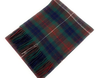 May include: A rectangular scarf with a classic plaid pattern in shades of green, navy blue, red, and brown. The scarf has a fringed edge and a white stripe. This accessory is suitable for cold weather.