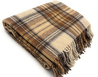 May include: A folded plaid blanket in shades of beige, brown, and tan. The blanket has a fringed edge and a classic tartan pattern. The soft, warm blanket is perfect for adding a touch of comfort to any room.